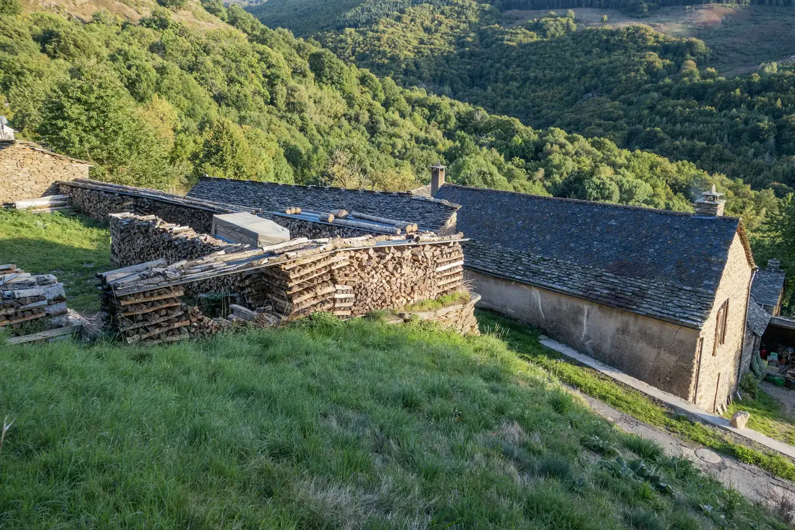 Hameau en pierre au milieu des collines boisées