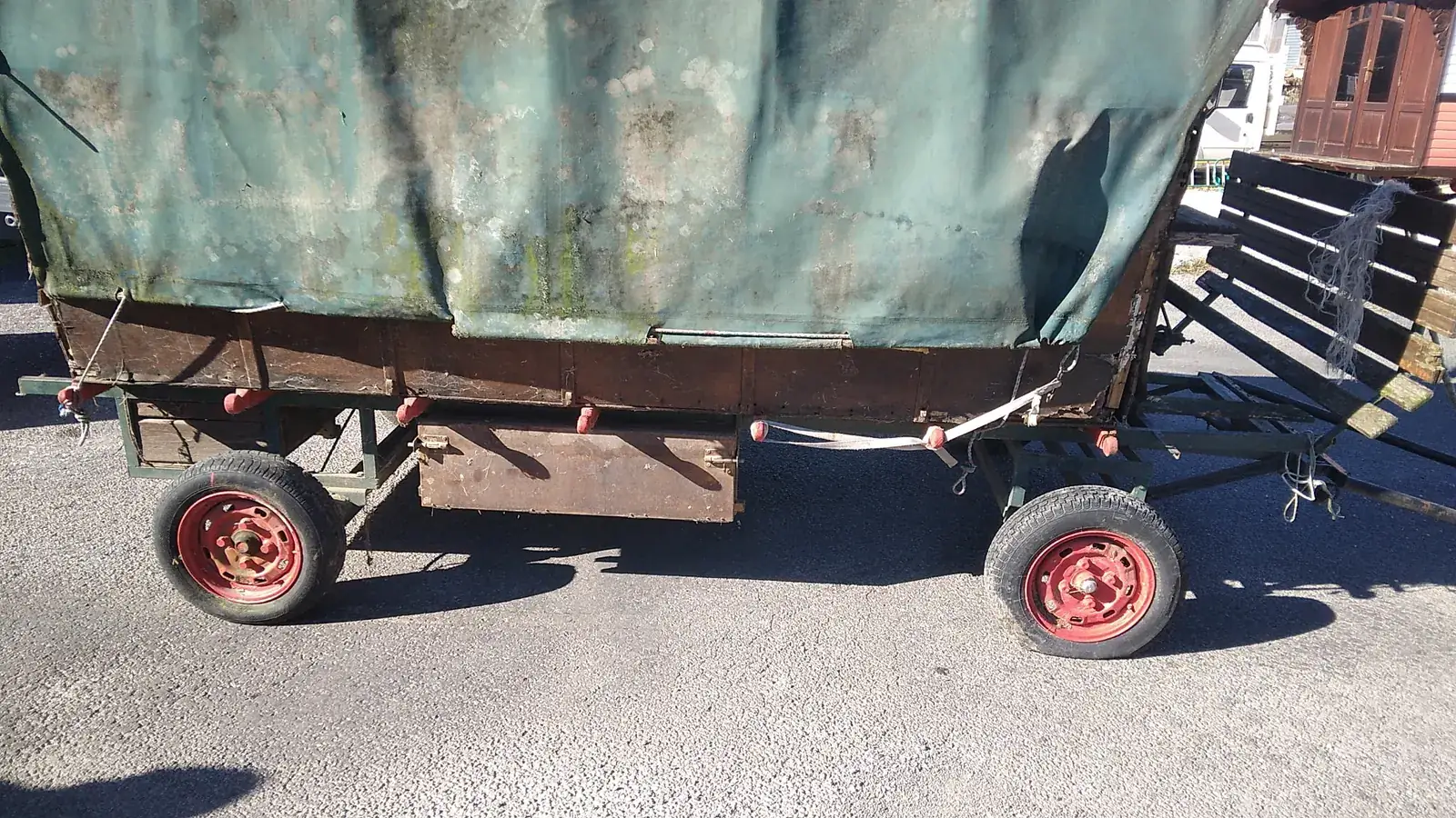 Ancienne charrette bâchée à roues rouges